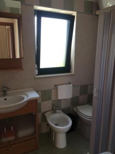 La salle de bains est pourvue d'un lavabo, de toilettes et d'une fenêtre. dans l'établissement Villa Irene, à Torre Santa Sabina