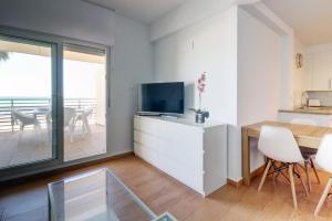 sala de estar con TV, mesa y sillas en Apartamento La Terraza del Mar en Cádiz
