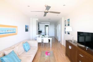 a living room with a couch and a flat screen tv at Apartamento Playa Victoria Cadiz in Cádiz