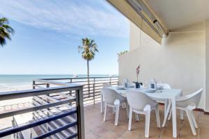un comedor con mesa y sillas y la playa en Apartamento La Terraza del Mar en Cádiz