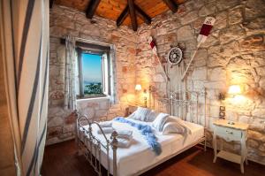 ein Schlafzimmer mit einem Bett in einer Steinmauer in der Unterkunft Kavos Psarou Villas in Ammoudi