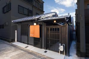 an entrance to a building with an open gate at Kanade Kyotoeki-Minami in Kyoto