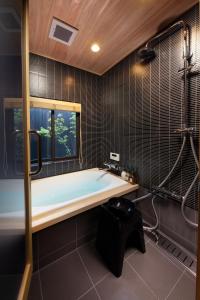 baño con bañera grande y ventana en Kanade Kyotoeki-Minami, en Kioto
