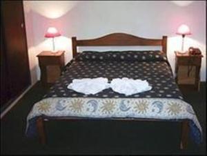 a bedroom with a bed with two white towels on it at Posada La Campiña in Valle Hermoso