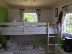 a room with two bunk beds with a window at UrKräuterwagen in Leutschach