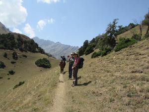 a group of people riding horses down a dirt trail at Tilek Guest House in Sary-Mogul
