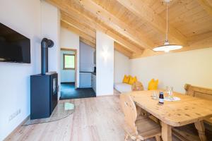 - un salon avec une table en bois et une télévision dans l'établissement Hütterhof, à Lagundo