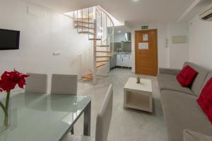 a living room with a couch and a glass table at Reservaloen Mariano de Cavia in Seville