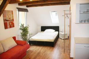 1 dormitorio con cama y sofá en Hermann's Neue Post, en Calw