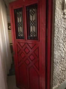 een rode deur met enkele ramen aan een muur bij very comfortable and cozy in Caïro