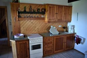 uma cozinha com armários de madeira e um forno de fogão branco em Ferienhaus Kreiner em Sankt Kathrein am Offenegg