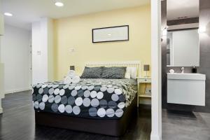 1 dormitorio con 1 cama con edredón blanco y negro en Apartamento Principe Pio, en Madrid