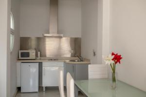 a kitchen with a table with a vase of flowers at Reservaloen Mariano de Cavia in Seville