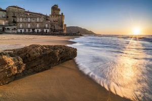 a beach with a building and the ocean at Casa Tresinus in Santa Maria di Castellabate