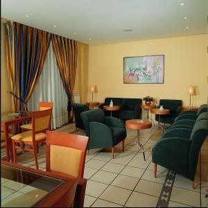 a waiting room with green chairs and tables at Hotel Isabel in Briviesca