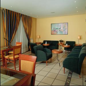 una sala de espera con sillas y mesas verdes en Hotel Isabel, en Briviesca