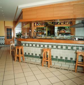 una cocina con taburetes de madera y una barra en un restaurante en Hotel Isabel, en Briviesca