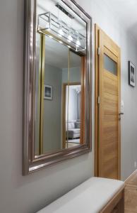 a mirror on a wall next to a door at AMN APARTMENTS in Warsaw