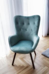 a green chair sitting in a living room at AMN APARTMENTS in Warsaw