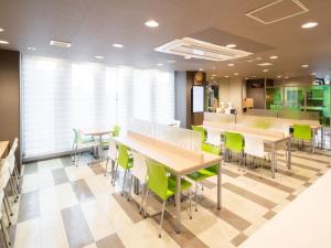 una cafetería con mesas, sillas y un mostrador en Super Hotel Fuji Inter, en Fuji
