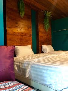 1 dormitorio con 1 cama grande y paredes de madera en Ruankaew Boutique Resort Lampang en Lampang