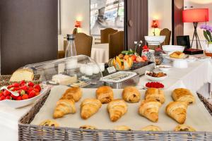 a buffet with croissants and other food on a table at Hotel Restaurant Charbonnel in Brantôme