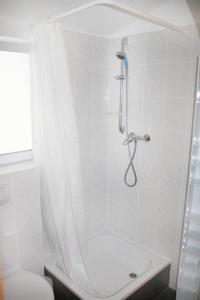 a white bathroom with a shower with a toilet at Hermann's Neue Post in Calw