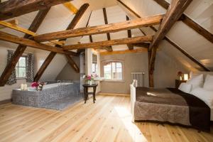 a attic bedroom with a bed and a bath tub at Gutshaus Lexow in Lexow