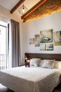 Un dormitorio con una cama grande y una ventana en Apartamentos Turisticos Moret 11 - 2A, en Cáceres