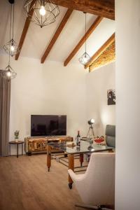 sala de estar con TV grande y mesa en Apartamentos Turisticos Moret 11 - 2A, en Cáceres