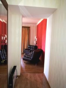 a living room with a black couch and a red wall at Apartment in the heart of Old Tbilisi in Tbilisi City