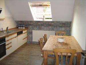a kitchen with a wooden table and chairs and a window at Ferienwohnung Alte Kämpe in Heede