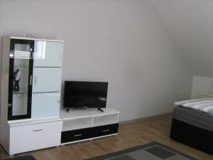 a living room with a tv on a white dresser at Ferienwohnung Alte Kämpe in Heede