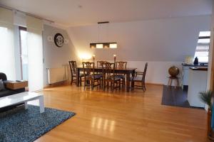 a dining room and living room with a table and chairs at FeWo LaChristina Köln-Bonn-Siegburg in Troisdorf