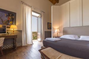 a bedroom with a bed and a television and a window at Masseria Agnello in Realmonte