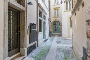 an alley in an old building with a green door at Maison Porta Leoni in Verona