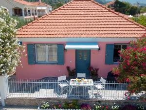 a pink house with a table and chairs at Sea Dream in Sami