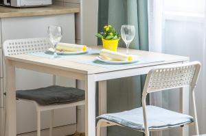 een witte tafel met twee stoelen en een tafel met wijnglazen bij Harrison(e) in Boedapest