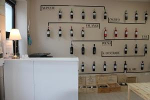 uma exibição de garrafas de vinho numa parede num quarto em La Maison em Vallata