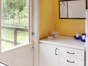 eine Küche mit einem Fenster und einem weißen Schrank in der Unterkunft 4 person holiday home in RKELJUNGA in Orkelljunga