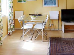 ein Esszimmer mit einem Glastisch und weißen Stühlen in der Unterkunft 4 person holiday home in RKELJUNGA in Orkelljunga