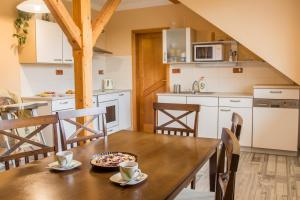 uma cozinha e sala de jantar com uma mesa de madeira em Rodinný apartmán Rodvínov em Rodvínov