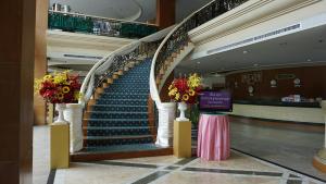 a staircase in a shopping mall with flowers on it at Wattana Park Hotel in Trang