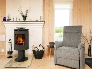 a living room with a chair and a fireplace at 4 person holiday home in Thisted in Thisted