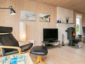 a living room with a chair and a television at 4 person holiday home in Thisted in Thisted