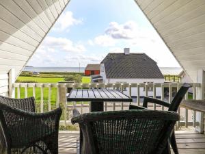 einen Tisch und Stühle auf einer Veranda mit Meerblick in der Unterkunft Holiday home Vestervig XXI in Vestervig