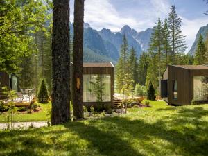 uma casa no meio de um campo com árvores em Skyview Chalets am Camping Toblacher See em Dobbiaco