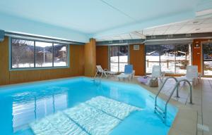 a large swimming pool with chairs in a room at Résidence Néméa Les Balcons d'Ax in Ax-les-Thermes