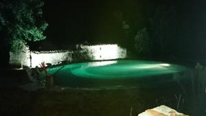 una piscina por la noche con iluminación verde en Domaine de Mombret Haut, en Duravel