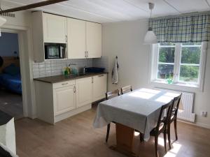 a kitchen and dining room with a table and chairs at Sättraby villa in Norrtälje